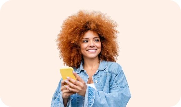 Smiling woman with curly hair holding a yellow phone