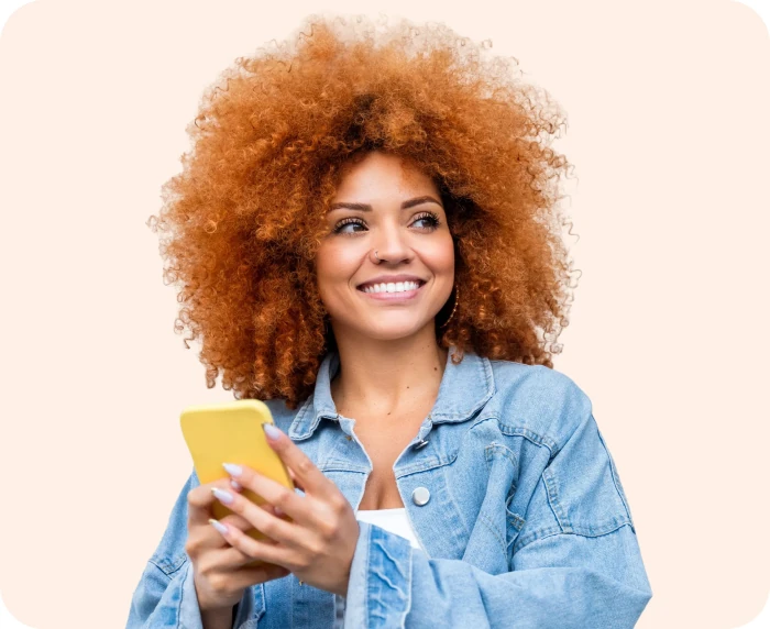 Smiling woman with curly hair holding a yellow phone