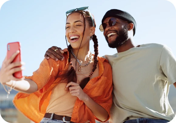 Laughing couple taking a selfie outdoors